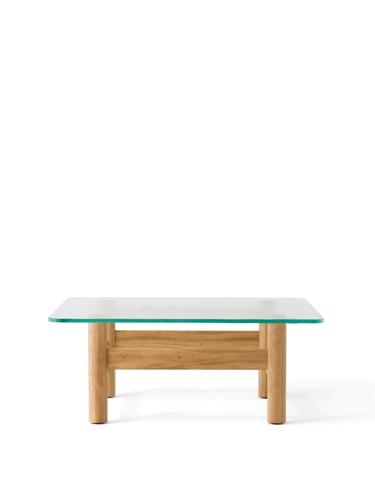 A front-on view of the Brasilia Lounge Table, featuring a thick, square glass top resting on a solid natural oak base.