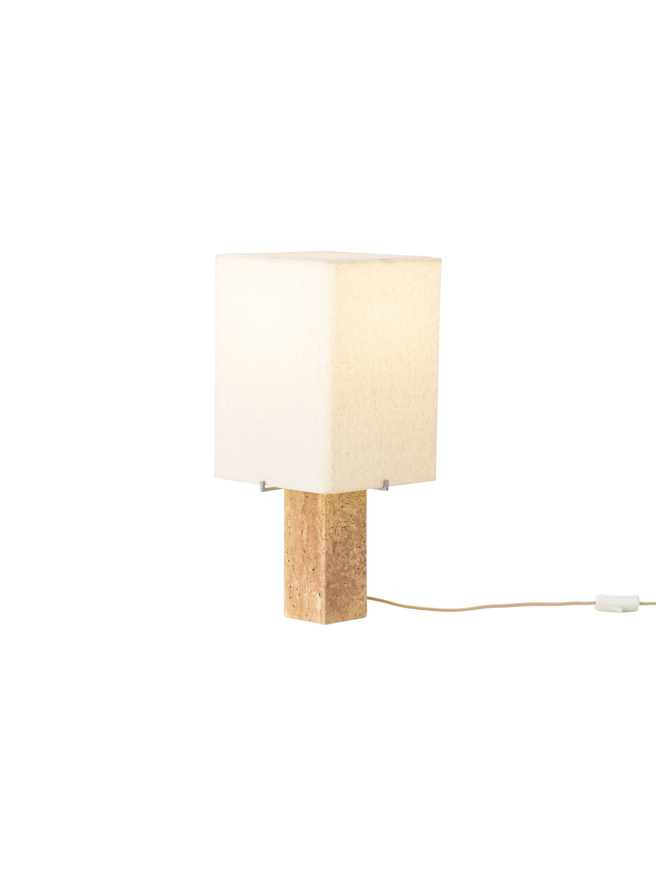 Angled view of the lit Nonna Table Lamp, featuring a square travertine base and a warm, glowing sand-coloured linen shade.