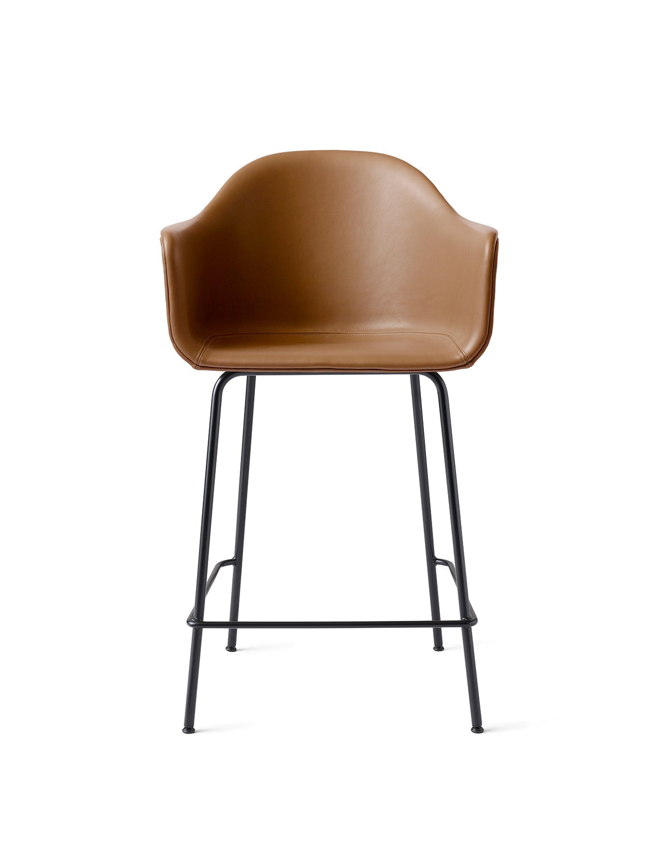 A Harbour Counter Chair seen from the front, with a tan leather upholstered shell, armrests, and a tall black steel base.