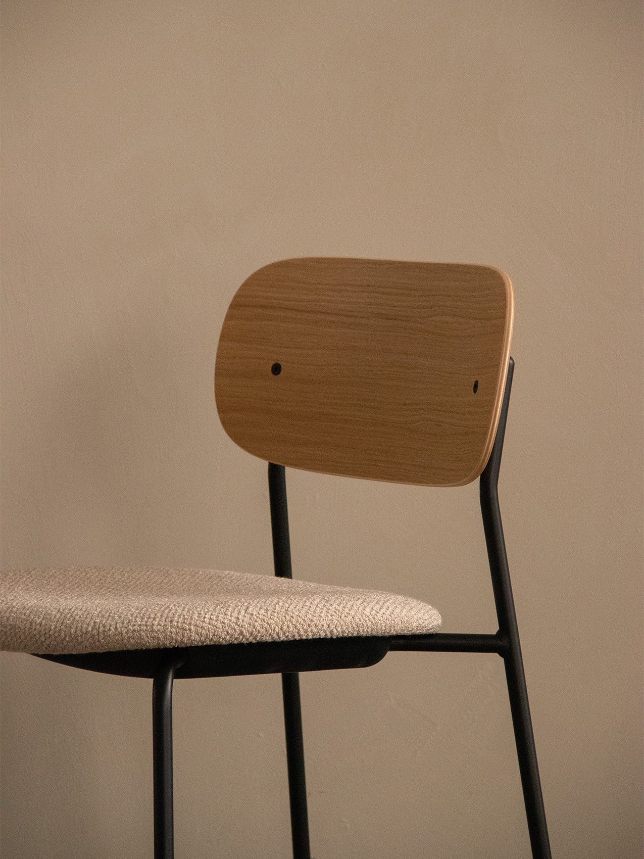 Co Bar Chair, Seat Upholstered, close-up showing the natural oak backrest and light upholstered seat on a black frame.