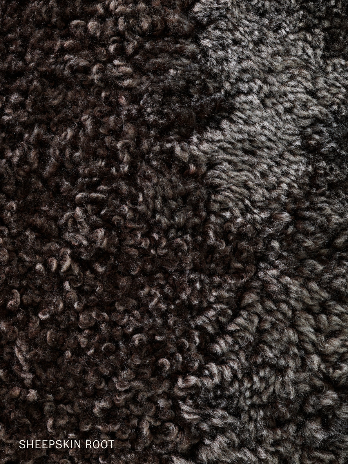 Close-up detail of the Brasilia Lounge Chair's Sheepskin Root upholstery, a curly, dense dark brown and grey fleece.