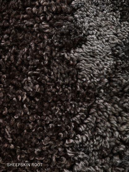 Close-up detail of the Brasilia Lounge Chair's Sheepskin Root upholstery, a curly, dense dark brown and grey fleece.