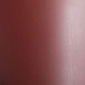 A close-up of a texture swatch in a burned red colour. The material has a smooth surface with a subtle sheen.