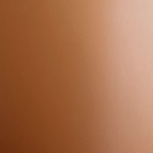A close-up of a material swatch with a matte, metallic finish. The colour is a warm bronze with a soft light gradient.