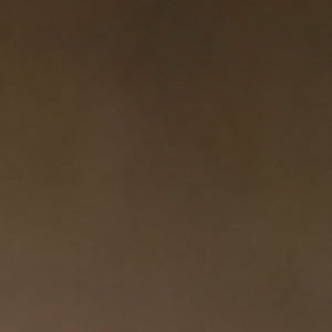 A close-up image of a dark brown glass material swatch.