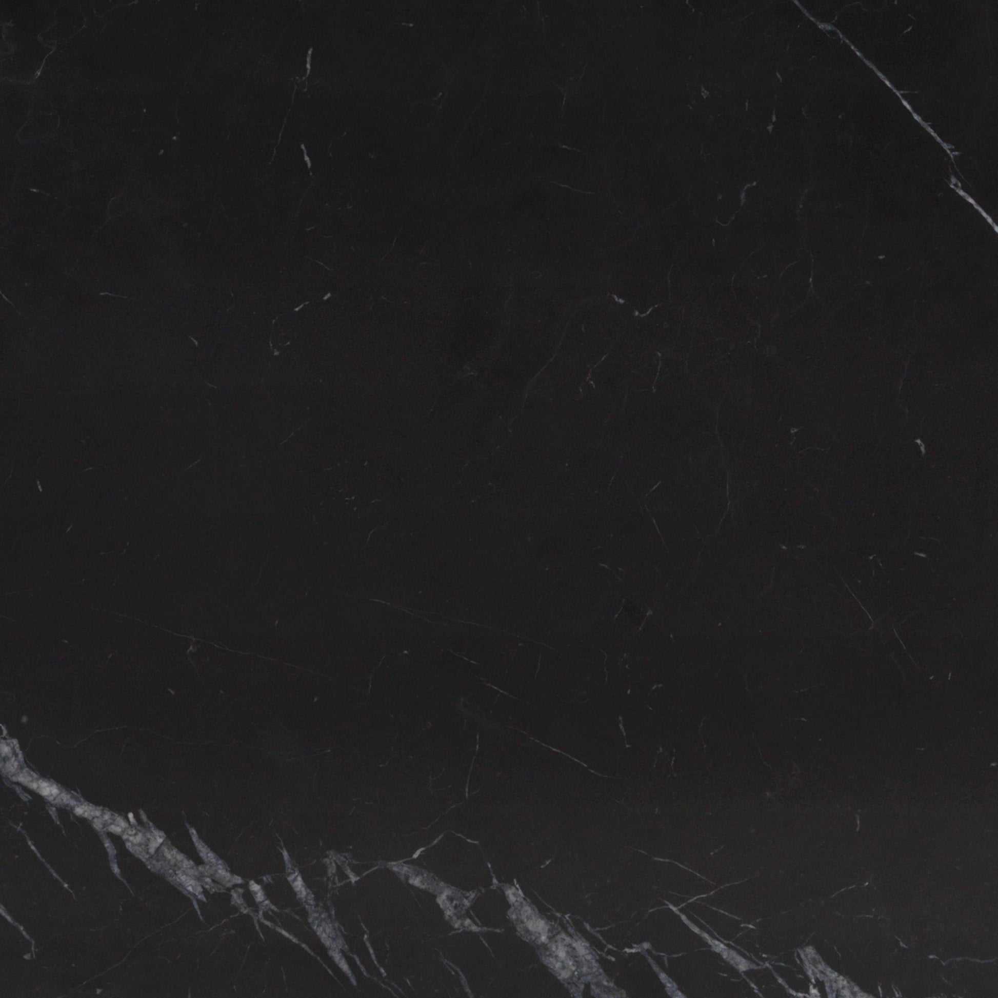A close-up view of a Nero Marquina marble slab, showcasing its deep black colour with distinctive white and grey veining.