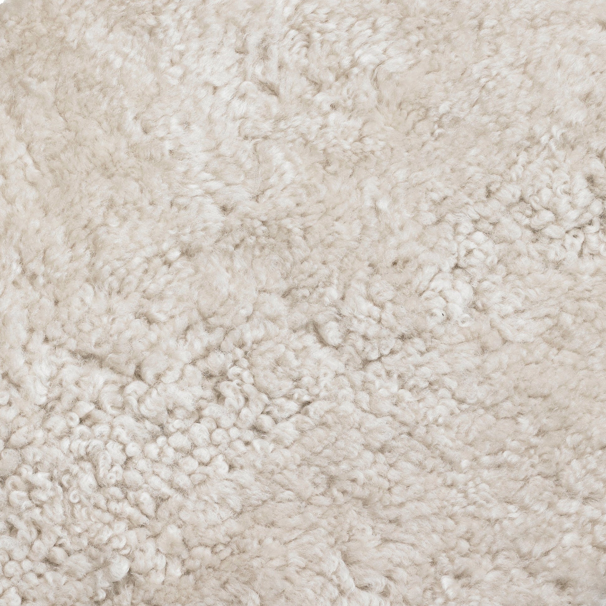 Close-up image of Skandilock Sheepskin in Moonlight, showcasing the material's dense, curly, and soft off-white texture.