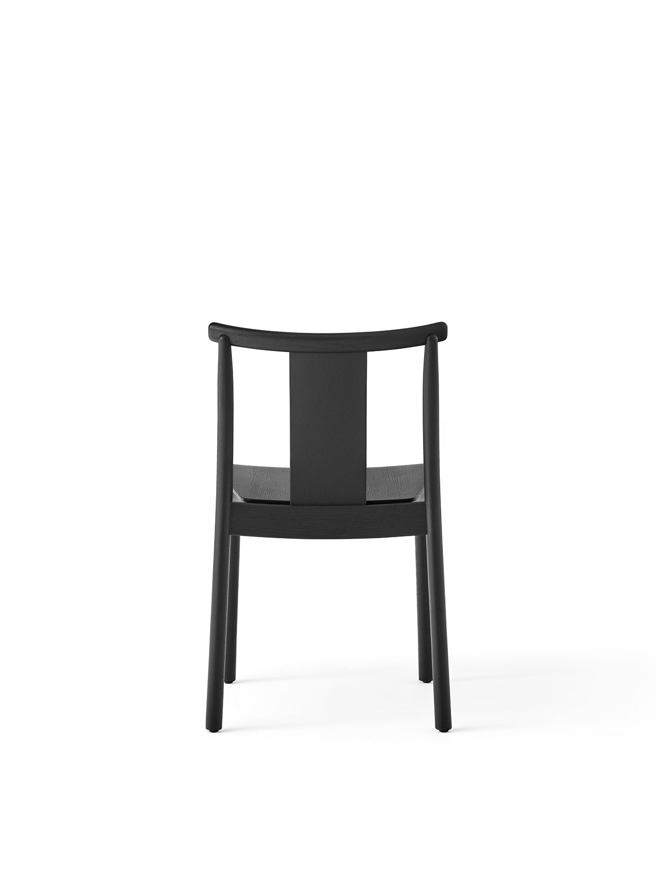 Back view of the Merkur Dining Chair in black oak, with its minimalist frame, curved top rail, and central back slat.