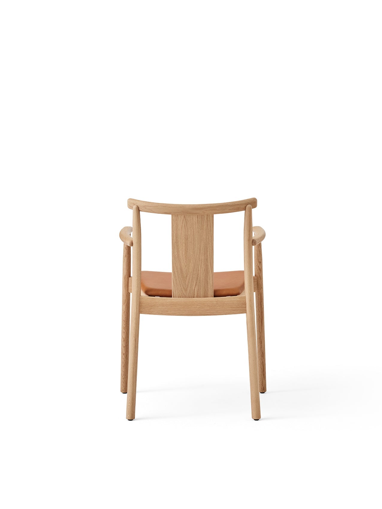 Rear view of the Merkur Dining Chair with Armrests in natural oak, featuring a tan leather seat pad on a white background.