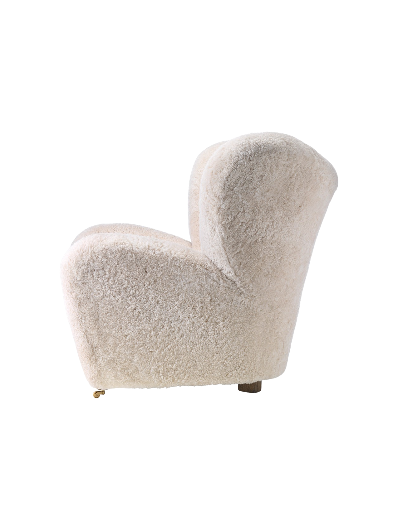 Side view of The Tired Man Lounge Chair upholstered in fluffy off-white sheepskin, showing its curved shape and wooden legs.