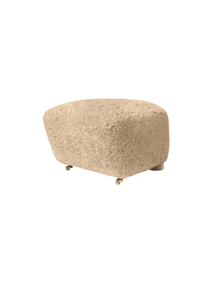 The Tired Man Ottoman upholstered in plush honey sheepskin. A rounded footstool with small brass castors on the front.
