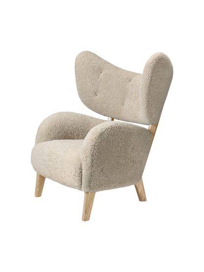 A three-quarter view of the My Own Chair in Moonlight sheepskin, featuring a high winged back and natural oak frame.