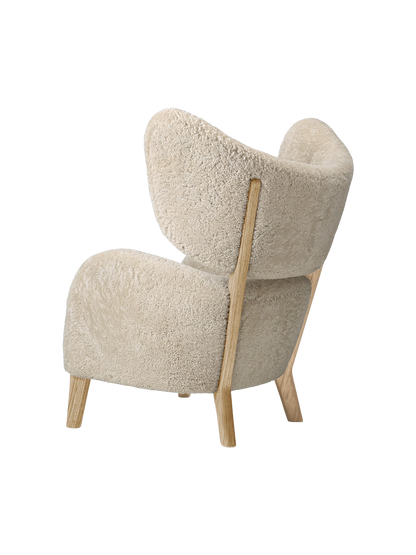 A three-quarter rear view of the My Own Chair, featuring plush Moonlight Sheepskin upholstery and a solid oak frame.