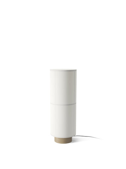 A white Hashira Floor Lamp seen from an angle, with a tall, cylindrical linen shade on a circular light ash wood base.