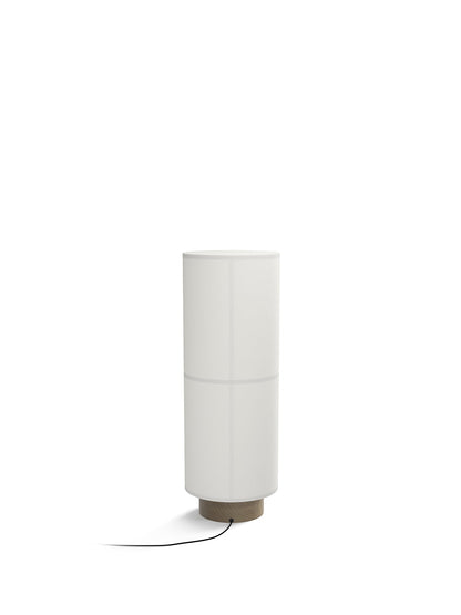 Back view of the Hashira Floor Lamp, with its white cylindrical linen shade atop a circular wooden base with a black cord.
