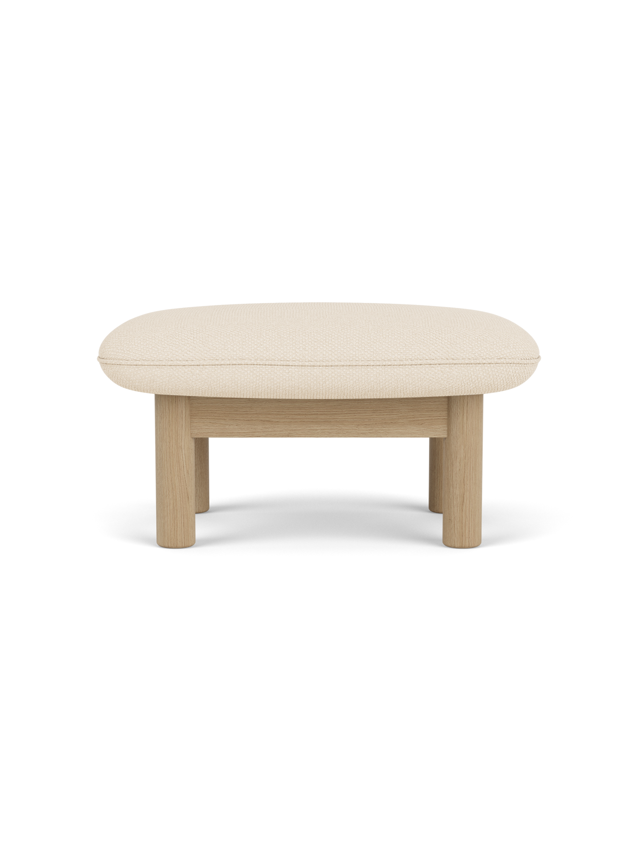 A side view of the Brasilia Ottoman with a natural oak frame and a light beige Logan Jasmine cushion on a black background.