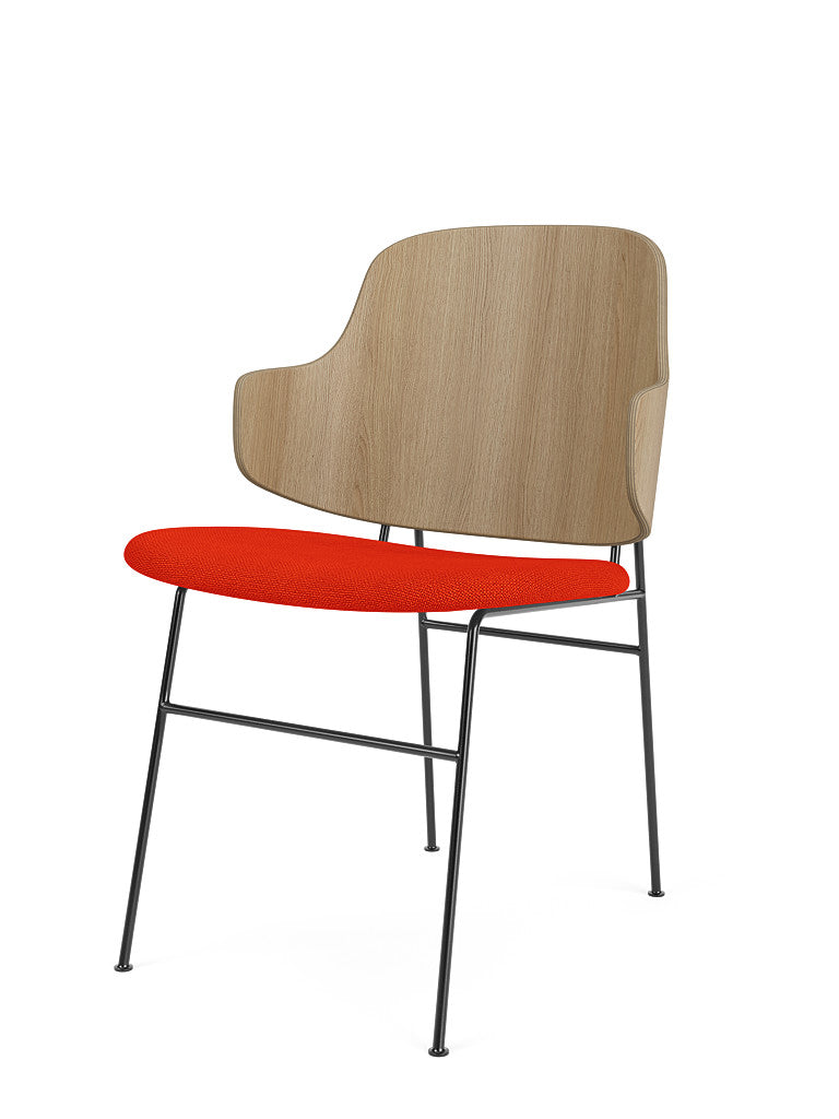 Angled view of The Penguin Dining Chair in natural oak, with a red Hallingdal 65 upholstered seat and a black steel frame.
