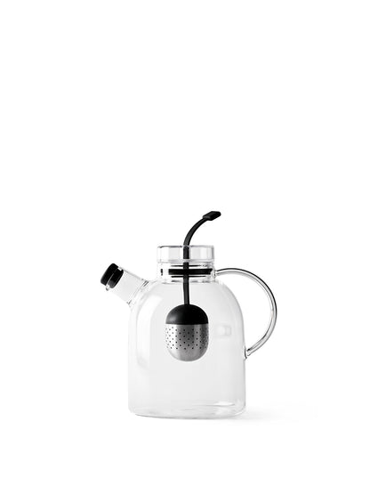 A clear glass Kettle Teapot with a handle and a small spout with a black cap. A black and silver tea infuser hangs inside.