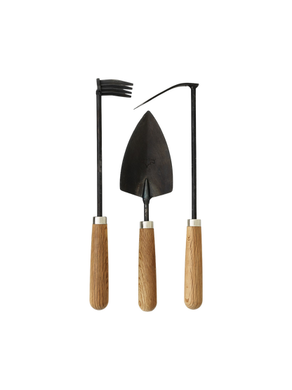 Pallares Plant Tool Set, showing three gardening hand tools—a rake, trowel, and hoe—with dark metal heads and wood handles.