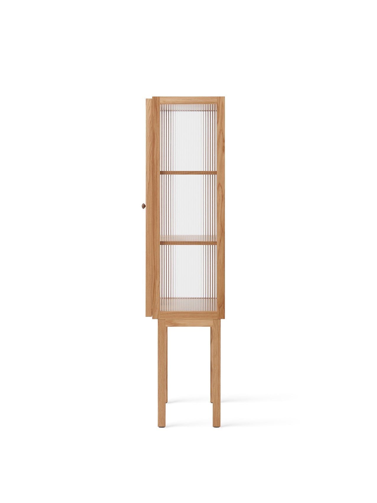 A side view of the tall Curiosity Cabinet in light oak. The cabinet's reeded glass door is slightly ajar, revealing shelves.