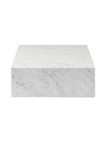 A side-on view of the rectangular Plinth Grand, a low plinth made of white Carrara marble with prominent grey veining.