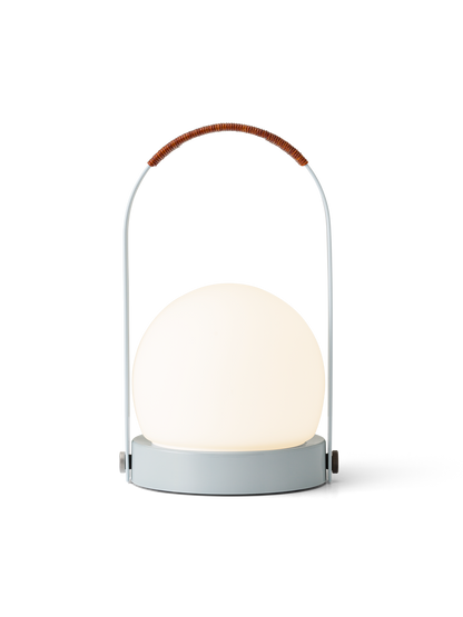 Linen Blue Carrie Portable Lamp featuring a rounded opal glass shade and a brown leather-wrapped handle.