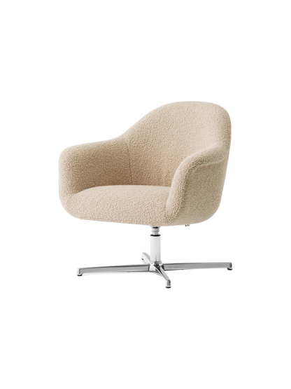 An angled view of the Harbour Lounge Chair, with light beige bouclé upholstery and a polished aluminium star swivel base.