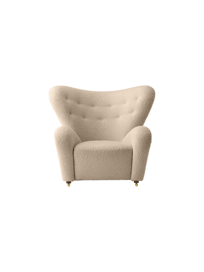 Front view of The Tired Man Lounge Chair in a cream textured fabric, with a high, curved back and button tufting.
