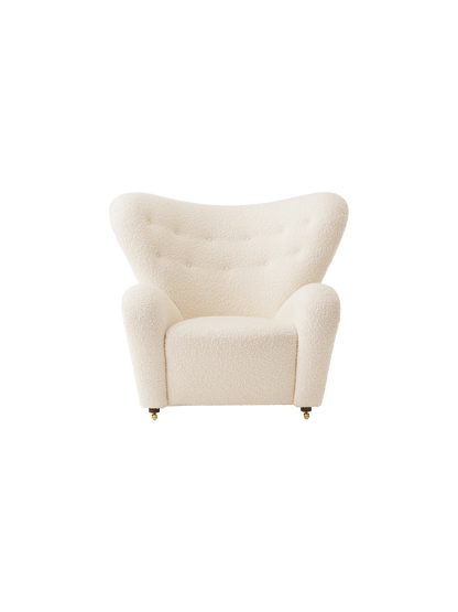 Front view of The Tired Man Lounge Chair. Upholstered in an off-white textured fabric with a high, winged, buttoned back.