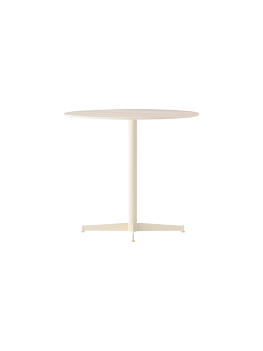 Angle view of the Nook Dining Table, featuring a round Estremoz Marble top and an ivory powder-coated steel four-star base.