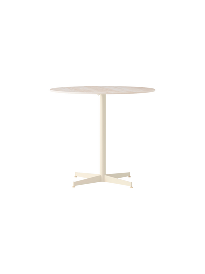 Front view of the Nook Dining Table with a round, light stone tabletop, a slim ivory central stem and four-star base.