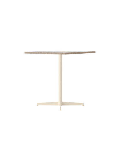 Angle view of the Nook Dining Table, featuring a rectangular Kunis Breccia stone top and an ivory four-star pedestal base.