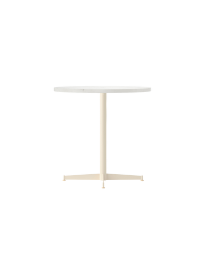Angled view of the Nook Dining Table, featuring a round white top and a slender, ivory-coloured pedestal base with four feet.