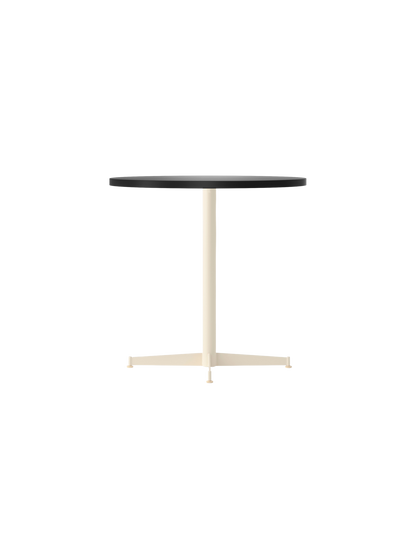 A Nook Dining Table shown from the side, with a round black tabletop and a slim, ivory-coloured, four-star pedestal base.