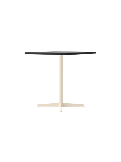 The Nook Dining Table shown with a dark rectangular top and a slim, ivory-coloured, four-star pedestal base.