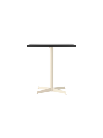 The Nook Dining Table with a rectangular charcoal linoleum tabletop on a slim, ivory, four-star base.