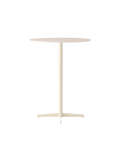 Angled Nook Bar Table with a round top and slender, four-legged ivory base against a black background.