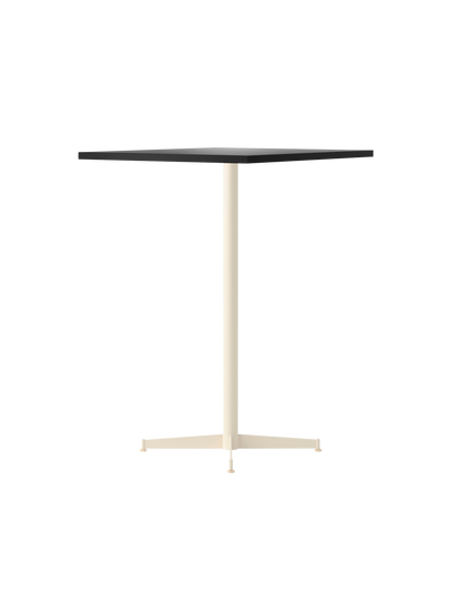 The Nook Bar Table, angled to show its rectangular charcoal linoleum top and slender, four-pronged ivory steel base.