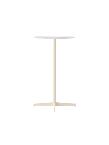 An angled view of the Nook Bar Table, featuring a round Estremoz marble top and a slim ivory-coloured steel base.