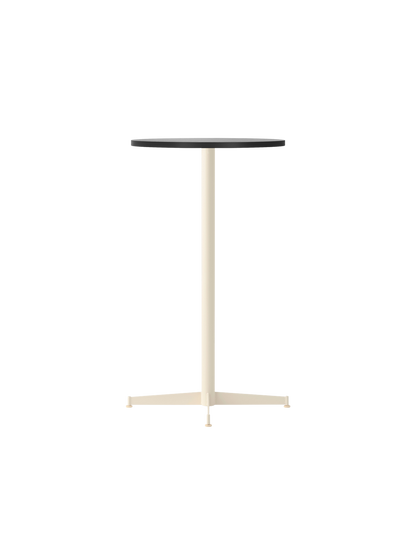 An angled shot of the Nook Bar Table, featuring a round black oak top supported by a slim, ivory-coloured pedestal base.