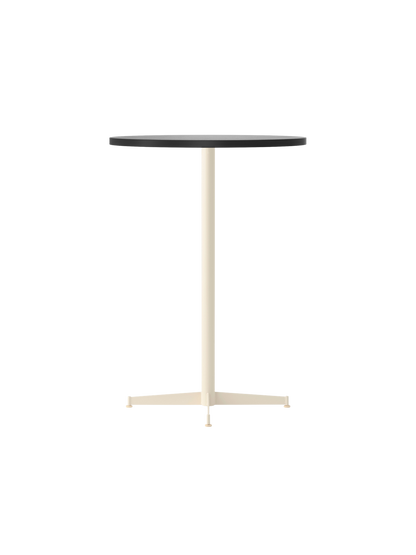 The Nook Bar Table seen from an angle, showing its dark circular tabletop and slender ivory-coloured pedestal base.
