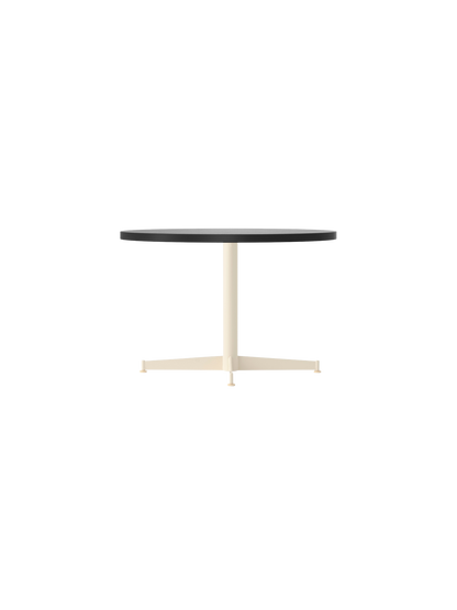 Side view of the Nook Lounge Table with a round, charcoal linoleum top and an ivory-coloured, four-star metal base.
