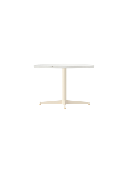 Angled view of the Nook Lounge Table featuring a round, light-coloured tabletop and an ivory four-star pedestal base.