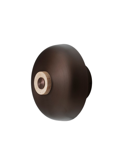 Angled view of the Reverse Wall Lamp, highlighting its bronzed aluminium shade and travertine dimmer.