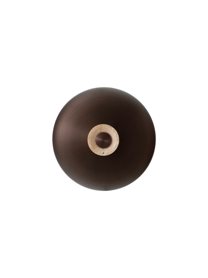 The Reverse Wall Lamp, front-on against a black background, with a bronzed aluminium shade and travertine base.