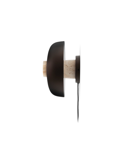 Side profile of the Reverse Wall Lamp, unlit, with a textured travertine base and smooth bronzed aluminium shade.