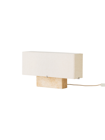 Side view of the wide Nonna Table Lamp with a rectangular travertine base and sand-coloured linen shade, shown switched off.