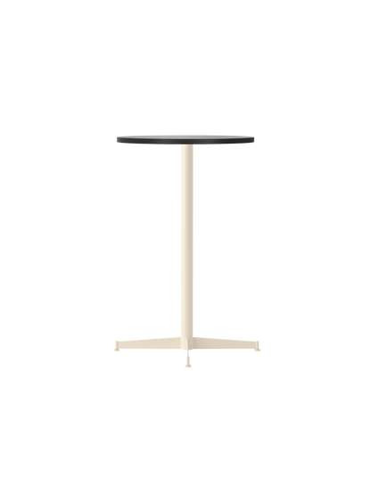 The Nook Counter Table with a round black oak top and an ivory pedestal base with four feet, viewed from an angle.