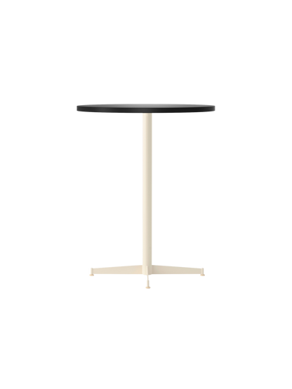 An angle view of the Nook Counter Table, featuring a round, charcoal linoleum tabletop and a slender, ivory-coloured base.