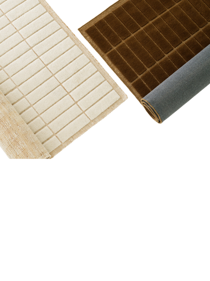A cream rug and a brown rug, both with a tactile grid pattern. The rugs are rolled back, revealing their different backings.